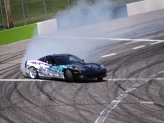 NJT Automation drift Corvette with Travis Weiss sliding through a corner at a motorsports event